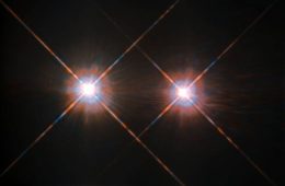 Two bright identical stars with diffraction spikes sit on a black background. The star on the left is slightly bigger than the star on the right.