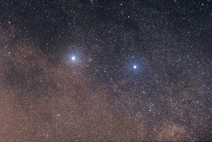 Image of two bright blue stars side by side and one dimmer circled star below, against a background of more distant stars.