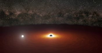 Illustration of a reddened disk of matter surrounding a large black hole. A bright flash of white light lies in one region of the disk.