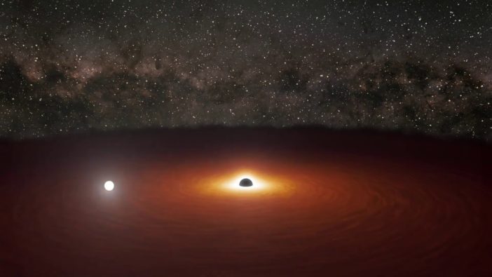Illustration of a reddened disk of matter surrounding a large black hole. A bright flash of white light lies in one region of the disk.