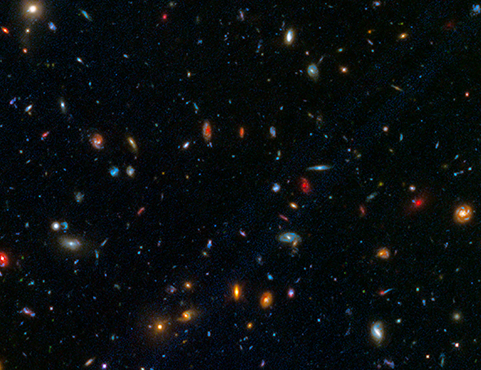 Image of a field containing hundreds of visible galaxies of different colors, shapes, and sizes.