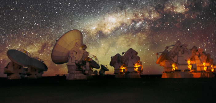 More than 10 radio telescopes point toward the sky in front of the Milky Way