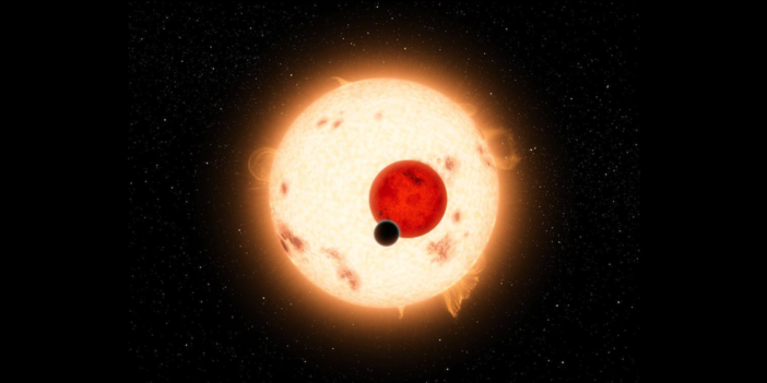 A large planet silhouetted against a small red star and a larger yellower star with starspots