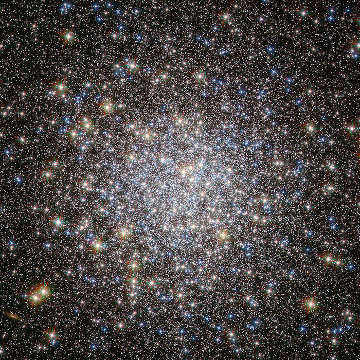 A globular cluster, densest at the center, with stars of several different colors