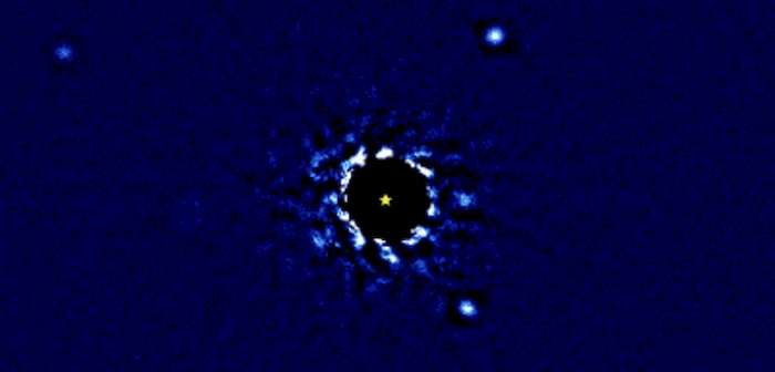 Four bright circles appear at varying distances from a central star