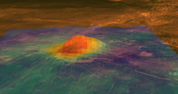 A rounded volcanic peak rises in the center of the image. The warmest part of the heat pattern overlay is found near the peak and on one side of the volcano