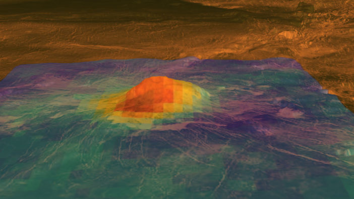 A rounded volcanic peak rises in the center of the image. The warmest part of the heat pattern overlay is found near the peak and on one side of the volcano
