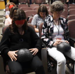Audience members holding a tactile star dome in a planetarium show for those with visual impairments.