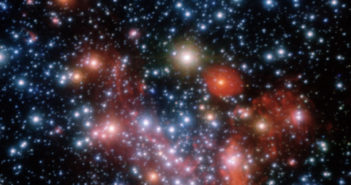 hundreds of densely packed glowing stars with some faint nebulosity