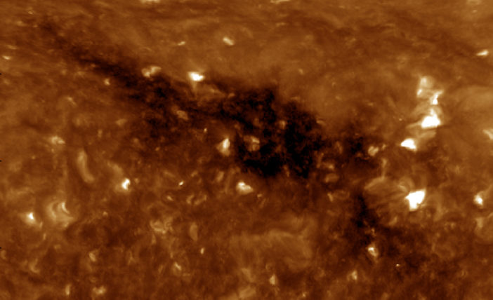 a coronal hole stretching diagonally across an extreme ultraviolet image of the Sun
