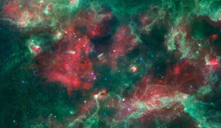 intricate tendrils and clumps of gas and dust stretch across a star-forming region dotted with young stars