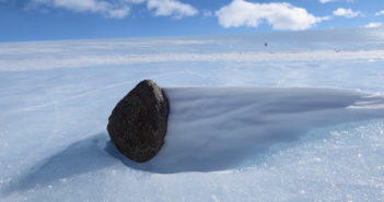 photograph of an asteroid meteorite sitting on ice