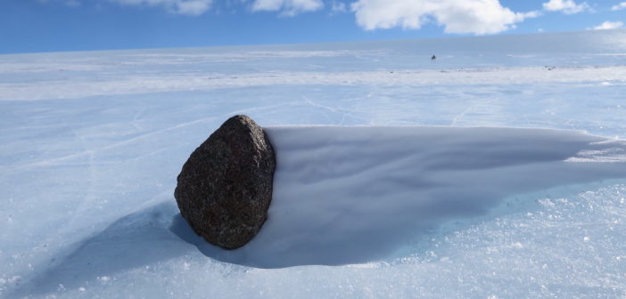 photograph of an asteroid meteorite sitting on ice