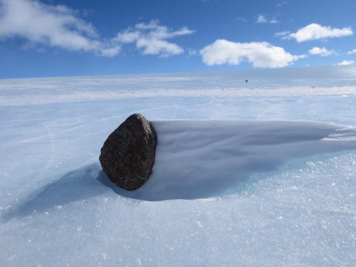 photograph of an asteroid meteorite sitting on ice