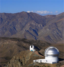 photograph of a mountain ridge with two telescopes
