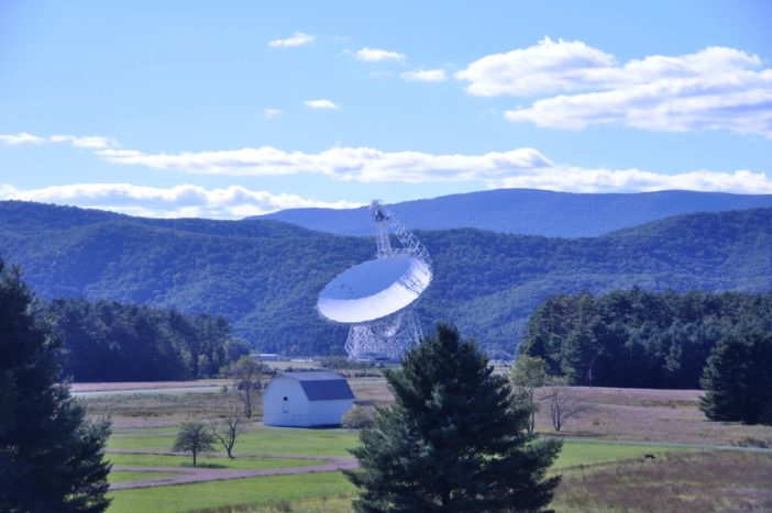 photograph of the green bank telescope in front of rolling mountains