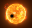 An illustration of an opaque planet transiting in front of a star. The planet is surrounded by a comet-like coma of darker material.