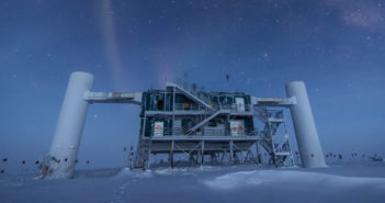 A photograph of a building and other infrastructure atop an ice sheet at night. Several stars are visible overhead.
