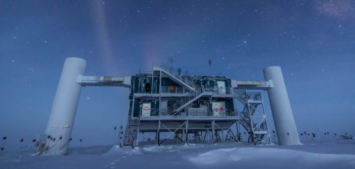 A photograph of a building and other infrastructure atop an ice sheet at night. Several stars are visible overhead.