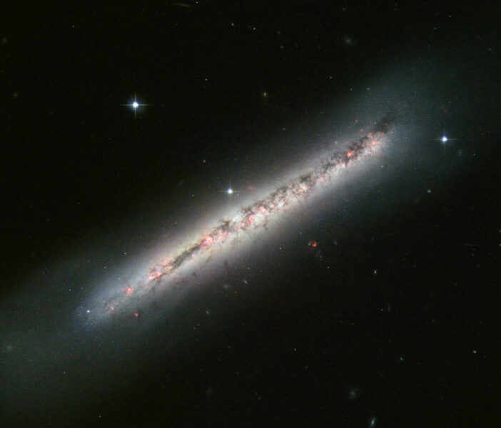 A photograph of a galaxy which appears in the foreground as a diagonal line because of the edge-on viewing geometry.