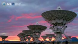 Photograph of an array of radio dishes against a sunset-illuminated sky.