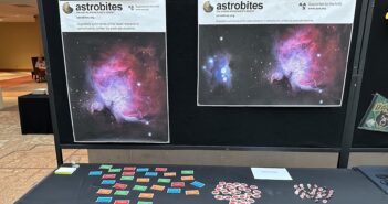 photograph of a booth with astrobites posters, stickers, and pins