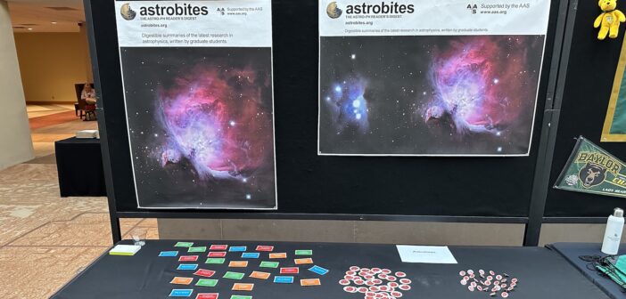 photograph of a booth with astrobites posters, stickers, and pins