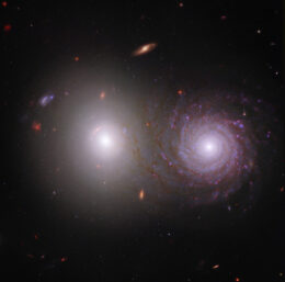 Hubble and JWST image of side-by-side elliptical and spiral galaxies