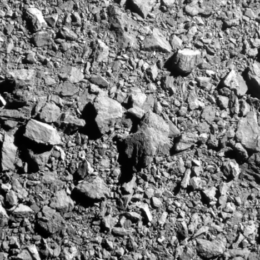 A greyscale photograph of a rocky surface.