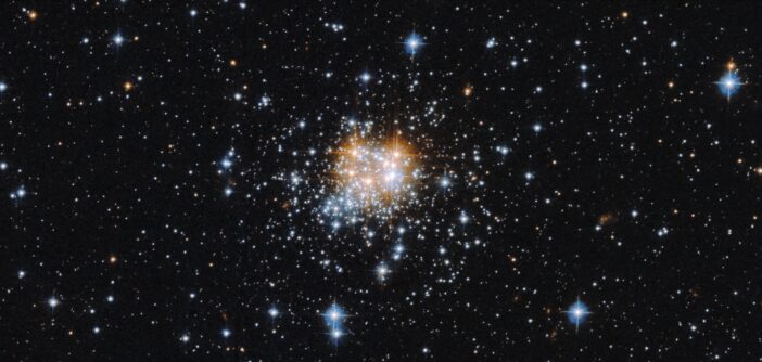 A photograph of a dense knot of stars against a collection of more spread-out stars.