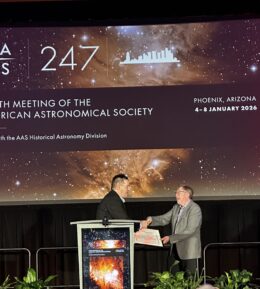 Thomas A. Hockey accepting the Doggett Prize on stage at the AAS 247 meeting, with the conference backdrop visible behind him.