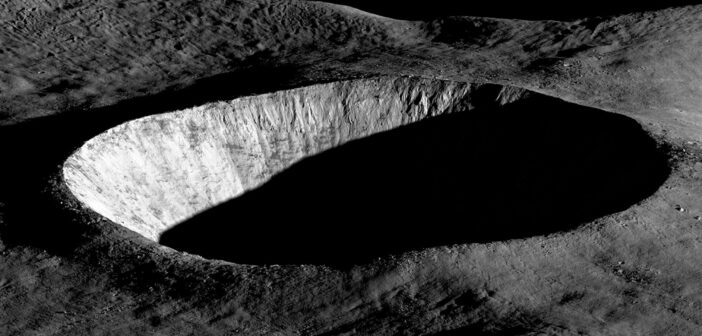 An oblique-angle photograph of a deep crater half in shadow.