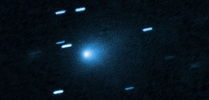 A photograph showing a fuzzy comet coma and some streaked stars alongside.