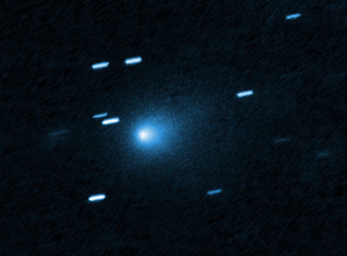 A photograph showing a fuzzy comet coma and some streaked stars alongside.